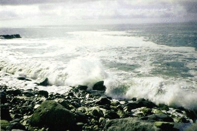 Big waves crash against the rocks.